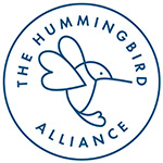 A circular logo with a simple line drawing of a hummingbird in the center. Around the bird, the words THE HUMMINGBIRD ALLIANCE are written along the inside of the circle.